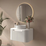 Bathroom setup with a white vanity, round mirror, and decorative elements.
