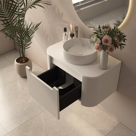 Bathroom vanity with open drawer, sink, and decorative elements.