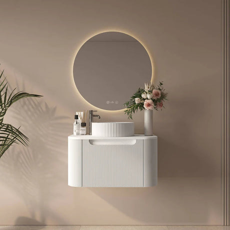 Modern bathroom setup with a white vanity, round mirror, and decorative elements on a beige wall.