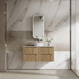 Bathroom with wooden vanity, sink, and mirror against a marble wall.