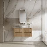 Bathroom with wooden vanity, sink, and mirror against a marble wall.