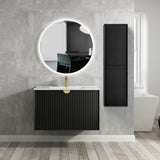 Bathroom with black vanity unit, round mirror, and tall black cabinet.