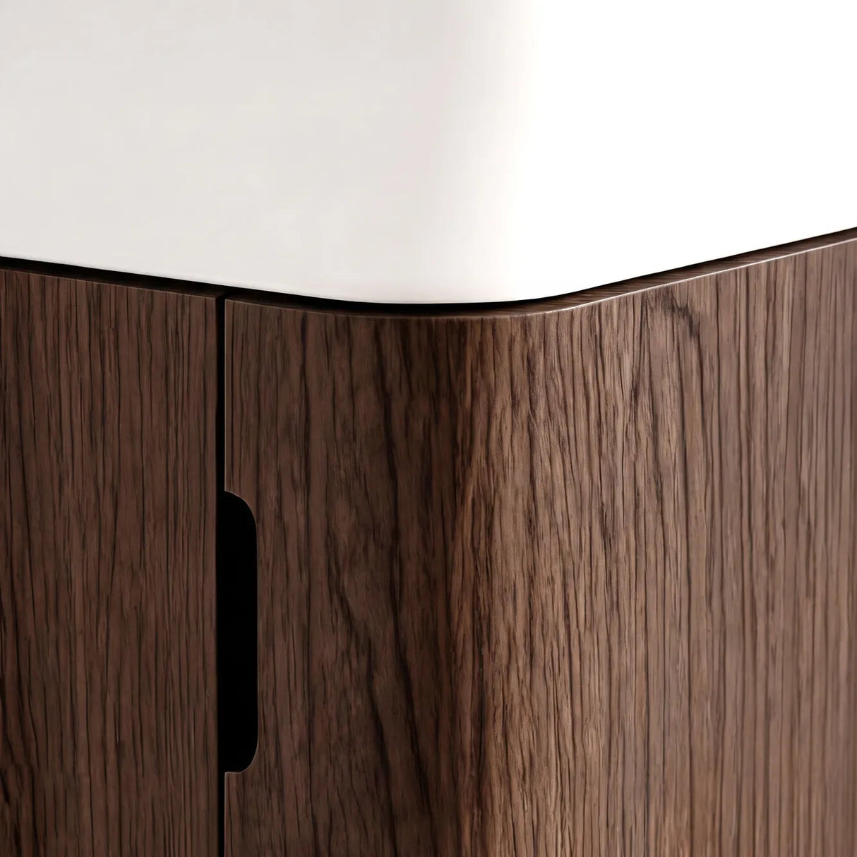 Close-up of a modern cabinet corner with dark brown wood grain doors and a white curved top surface.