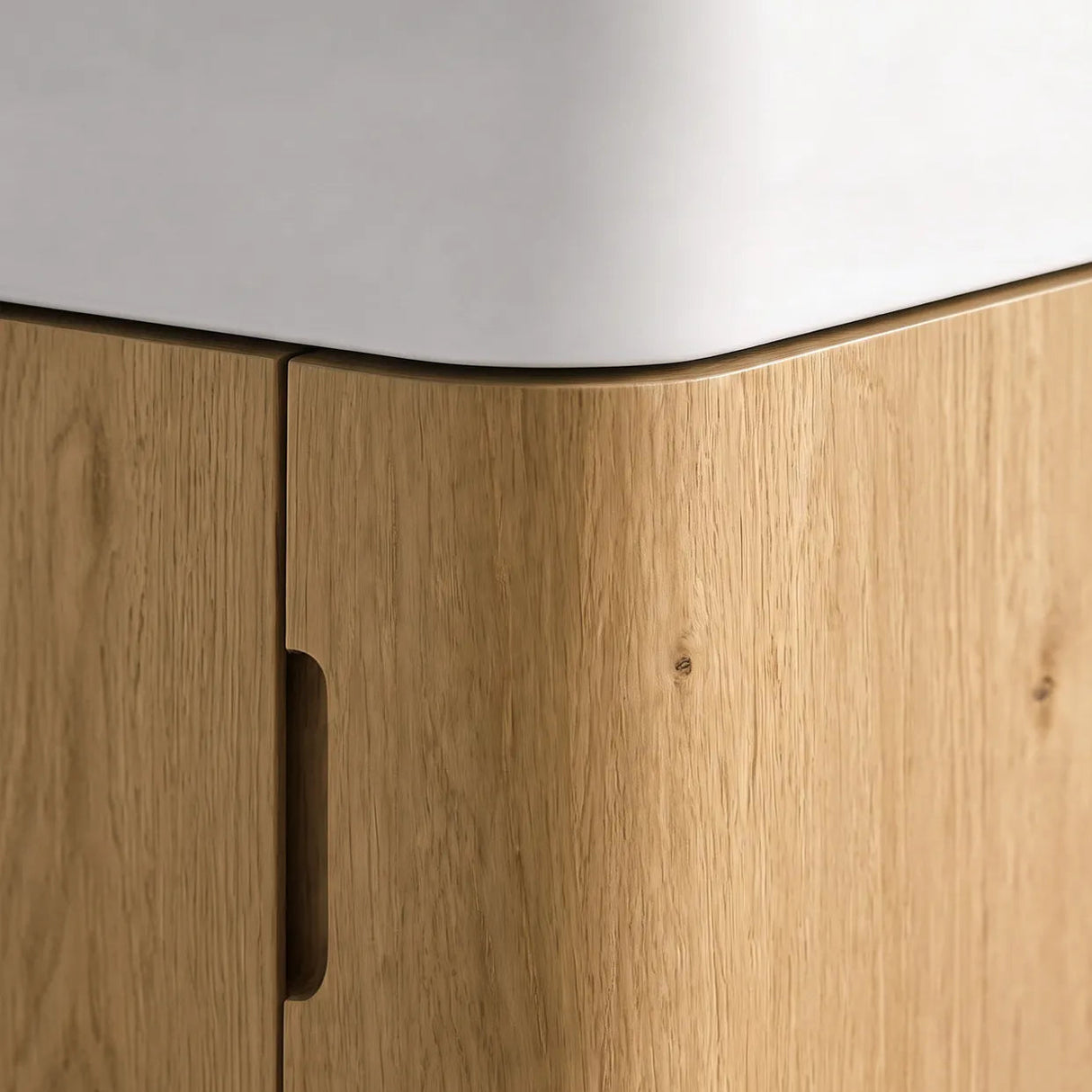 Close-up of a corner cabinet with light oak wood grain doors and a white countertop.