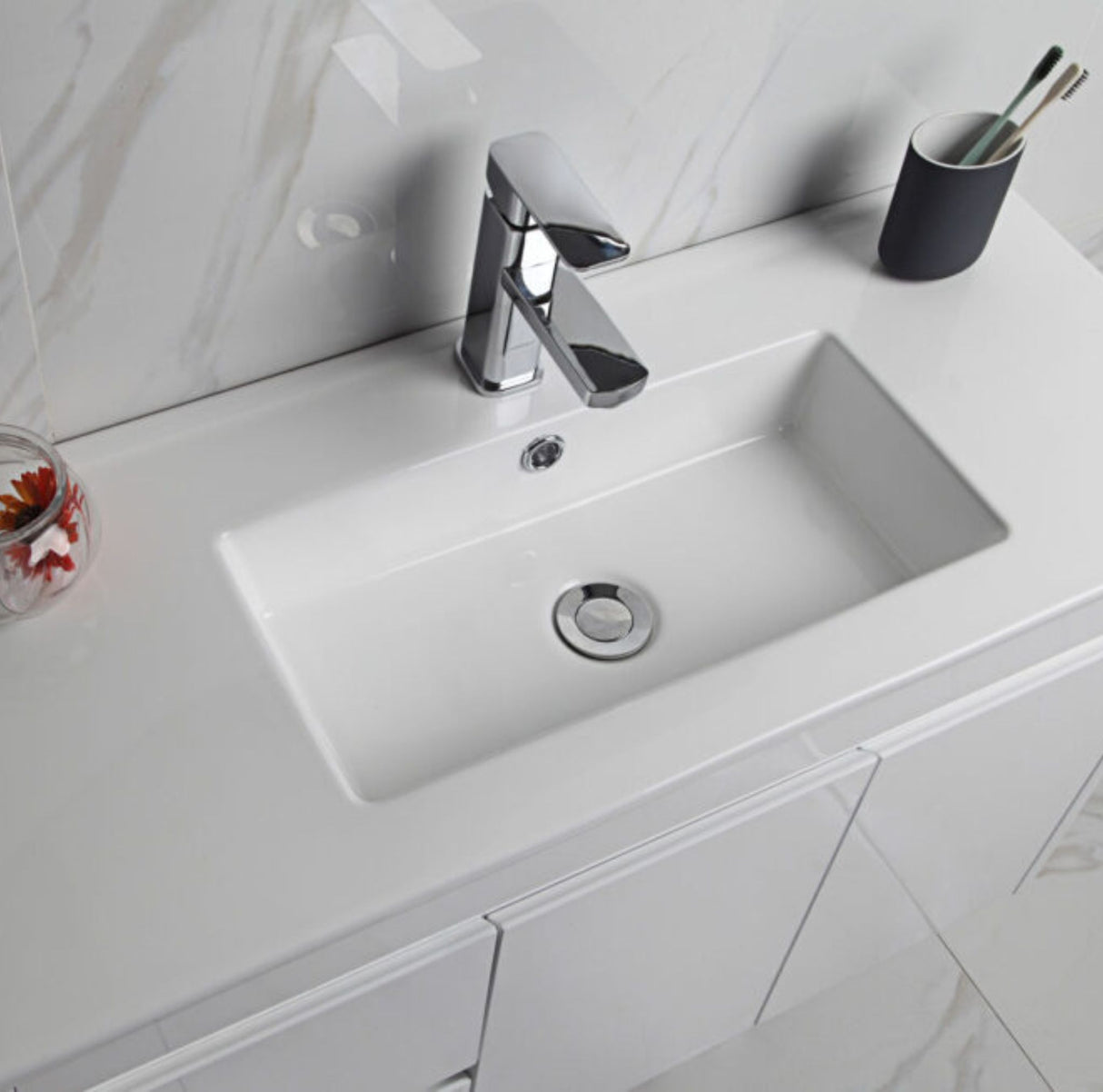 Bathroom sink with faucet and cup holder on a white countertop