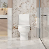 Modern toilet in a bathroom with marble walls and a glass shower enclosure.