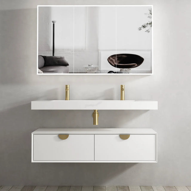 Bathroom vanity with white countertop and gold fixtures, large mirror above.