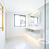 Modern bathroom with white tiles, a window, and a toilet.