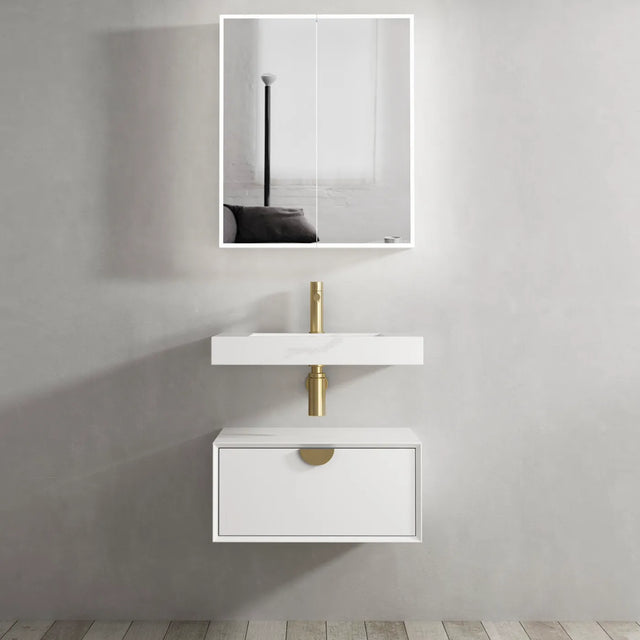 Bathroom vanity with white sink and gold faucet against a gray wall.
