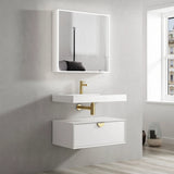 Bathroom vanity with white sink and mirror, gold fixtures, and a window in the background.