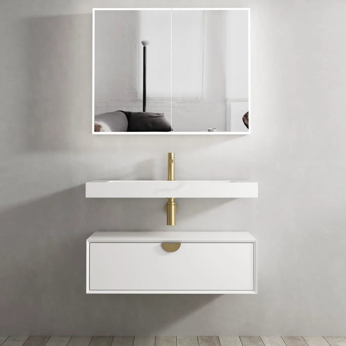Bathroom vanity with white sink and gold fixtures against a gray wall.