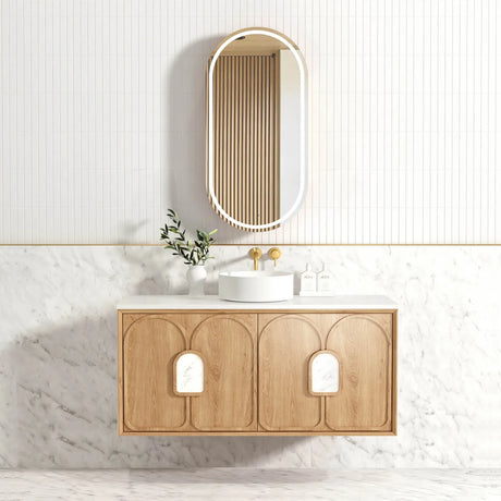 Bathroom vanity with wooden cabinet, white sink, and mirror on a light-colored wall.