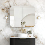 Bathroom with a modern vanity, round mirror, and decorative elements on a marble wall.