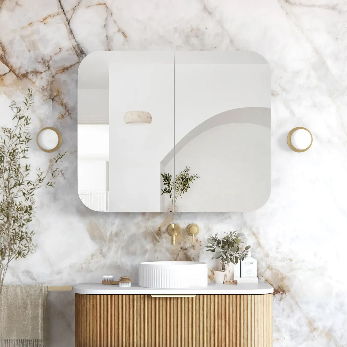 Modern bathroom with marble wall, wooden vanity, and decorative elements.