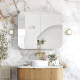 Modern bathroom with marble wall, wooden vanity, and decorative elements.