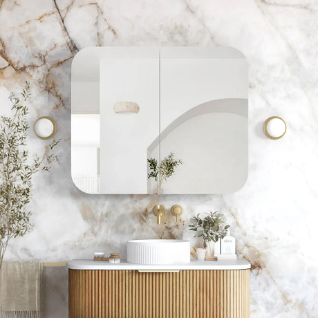 Modern bathroom with marble wall, wooden vanity, and decorative elements.