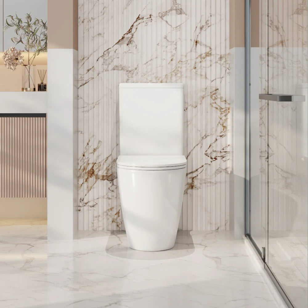 White toilet in a modern bathroom with marble walls and floor.