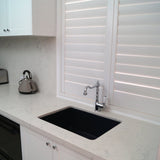 Modern kitchen with black sink and white cabinets
