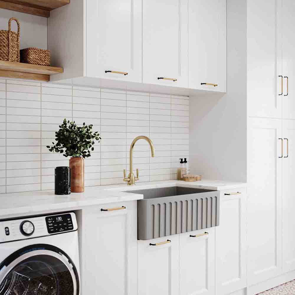 Modern kitchen with white cabinets, a washing machine, and a sink.