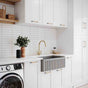 Modern kitchen with white cabinets, a washing machine, and a sink.