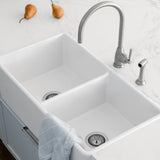 White kitchen sink with silver faucet and pears on a white countertop