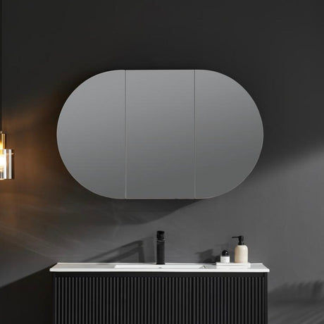 Bathroom with a large oval mirror above a vanity.