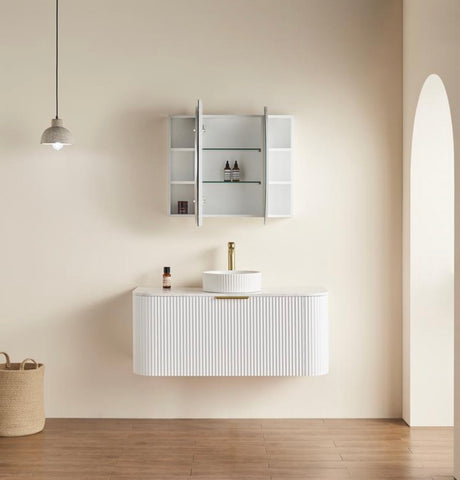 Bathroom setup with a white vanity, sink, and mirror cabinet against a beige wall.
