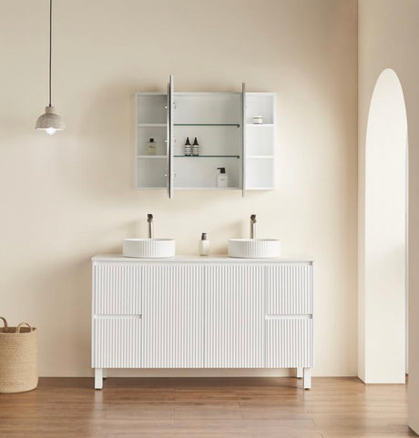 Bathroom vanity with two sinks and a mirror cabinet against a beige wall.