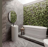 Modern bathroom with a freestanding bathtub, sink, and green wall feature.
