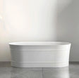 White freestanding bathtub against a plain wall