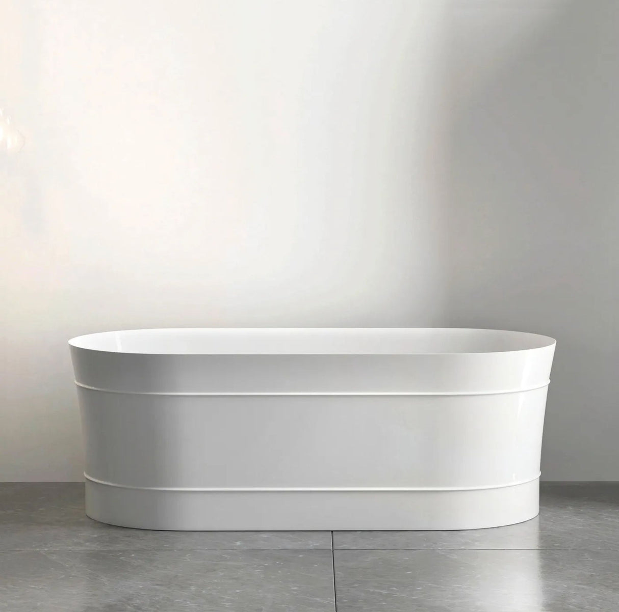 White freestanding bathtub against a plain wall