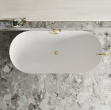 White oval sink with gold fixtures on a marble countertop