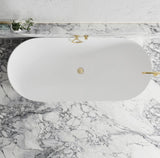 White oval bathtub with gold fixtures on a marble countertop