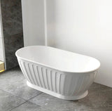 White freestanding bathtub in a bathroom setting with tiled floor and wall.