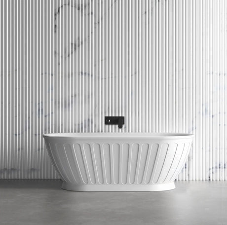 White freestanding bathtub with a black faucet against a striped wall.