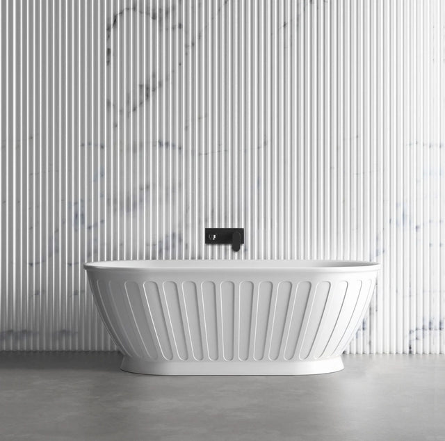 White freestanding bathtub with a black faucet against a striped wall.