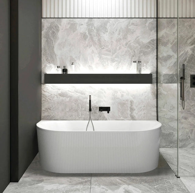 Modern bathroom with a back to wall bathtub against a textured wall.