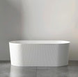 White freestanding bathtub against a plain wall