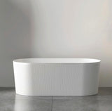 White freestanding bathtub against a plain wall