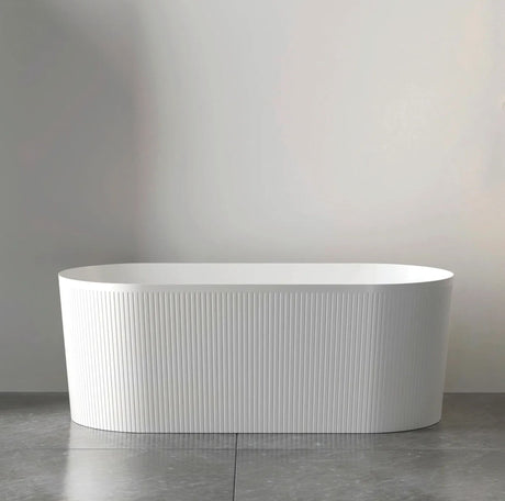 White freestanding bathtub against a plain wall