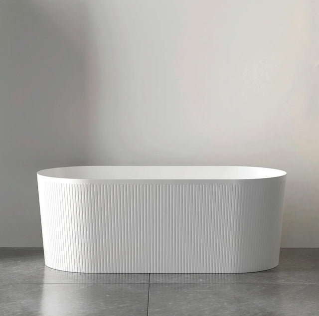White freestanding bathtub against a plain wall
