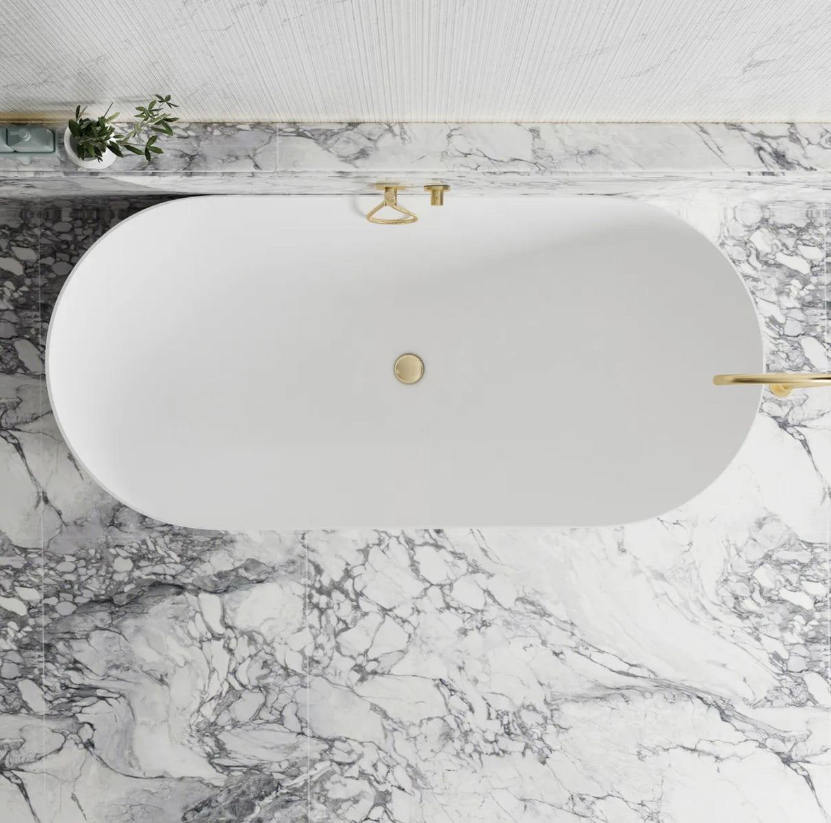 White oval sink with gold fixtures on a marble countertop
