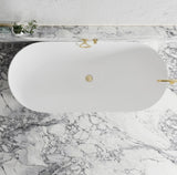 White oval bathtub with gold fixtures on a marble floor
