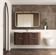 Modern bathroom with wooden vanity, mirror, and toilet against a marble wall.