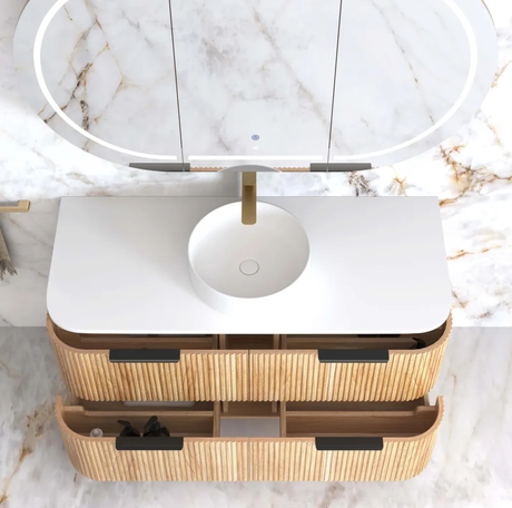 Bathroom vanity with rattan design and round mirror on marble countertop