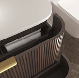 Bathroom vanity with open cabinet revealing folded towels, set against a neutral bathroom background.