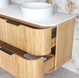Wooden bathroom vanity with white countertop and round white basin.