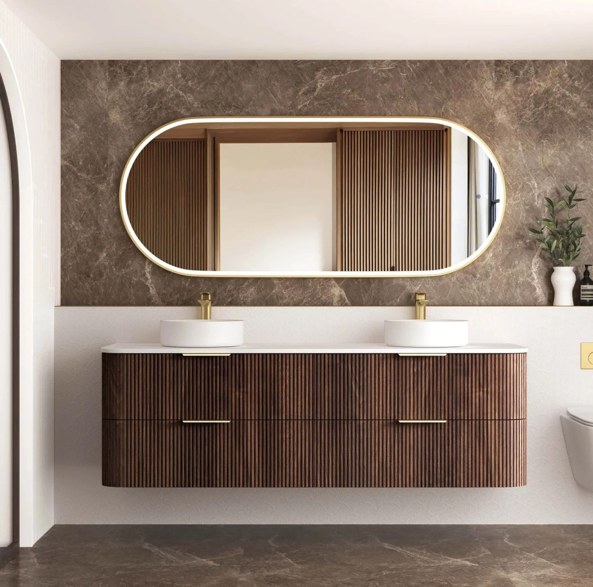 Bathroom vanity with wooden finish, two sinks, and a large mirror on a marble wall.