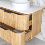 Wooden bathroom vanity with white countertop and round basin.