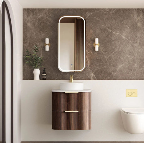 Modern bathroom with wooden vanity, mirror, and decorative elements.